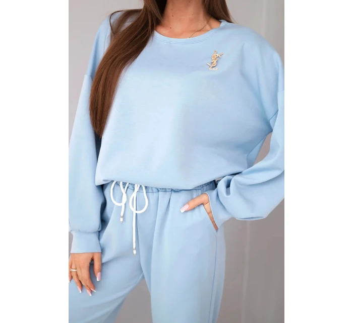 Dámský komplet máslový svetr s broží a kalhoty s rovnou nohavicí modrý Dámský komplet máslový svetr s broží a kalhoty s rovnou nohavicí modrý