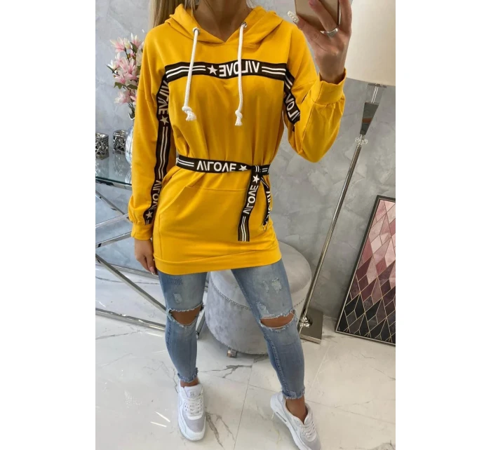 Šaty zdobené stuhou a nápisy v hořčicové barvě Šaty zdobené stuhou a nápisy v hořčicové barvě