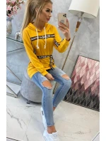 Šaty zdobené stuhou a nápisy v hořčicové barvě Šaty zdobené stuhou a nápisy v hořčicové barvě