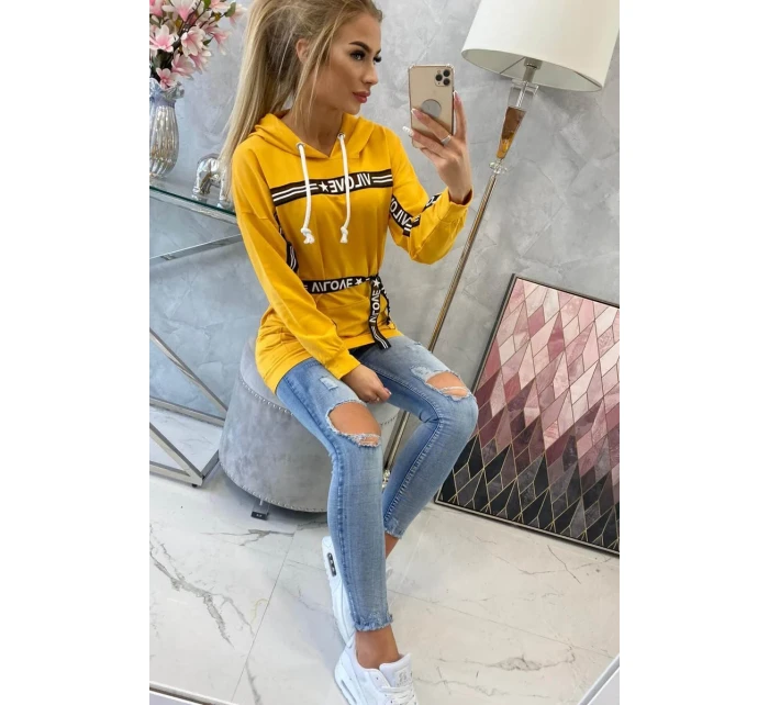 Šaty zdobené stuhou a nápisy v hořčicové barvě Šaty zdobené stuhou a nápisy v hořčicové barvě