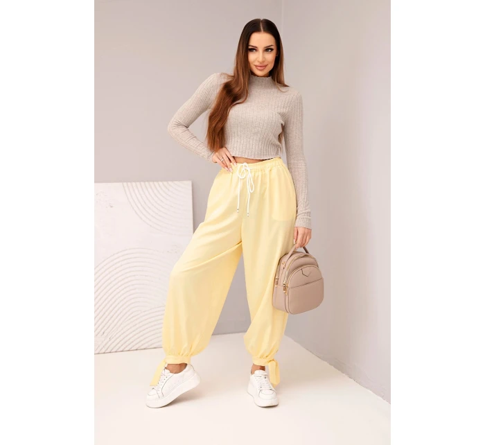 Dámské kalhoty s širokým nohavicím a zavazováním dole žluté