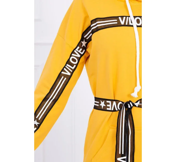 Šaty zdobené stuhou a nápisy v hořčicové barvě Šaty zdobené stuhou a nápisy v hořčicové barvě