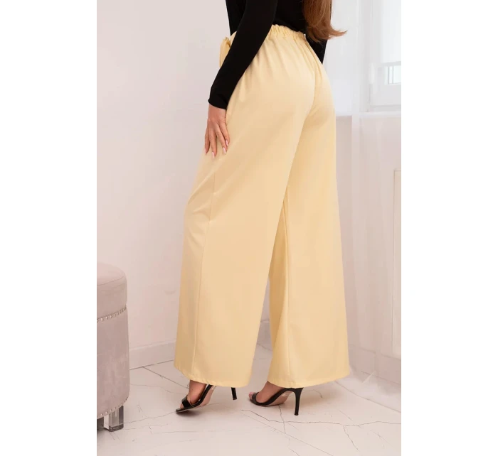 Dámské elegantní kalhoty s širokou nohavicí a ozdobným květem žluté Dámské elegantní kalhoty s širokou nohavicí a ozdobným květem žluté