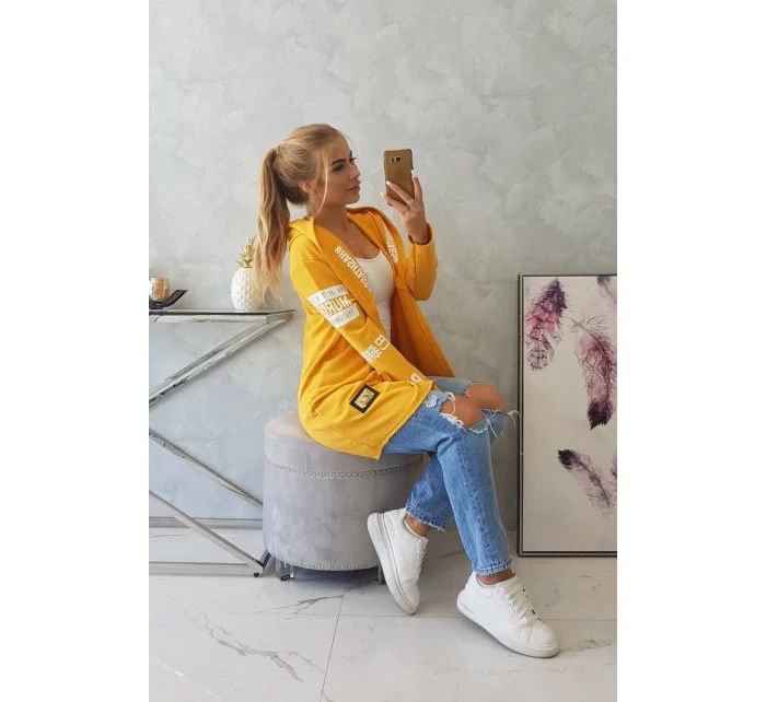 Plášť s hořčičným nápisem